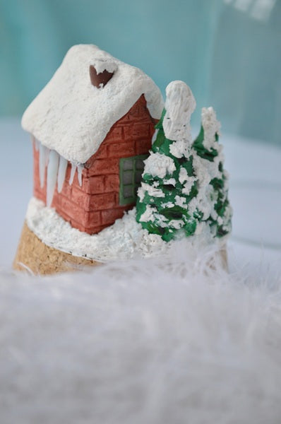 Gingerbread house with a tree on a white surface