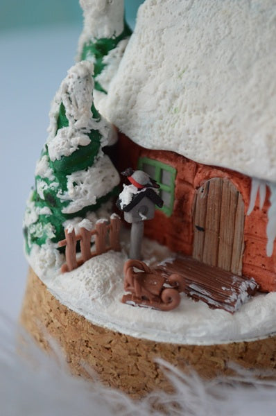 Decorative gingerbread house with a snowman and tree on a white background