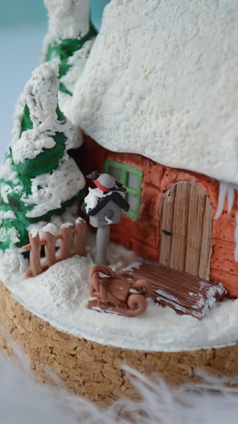 Gingerbread house with a snowman and sleigh on a white background