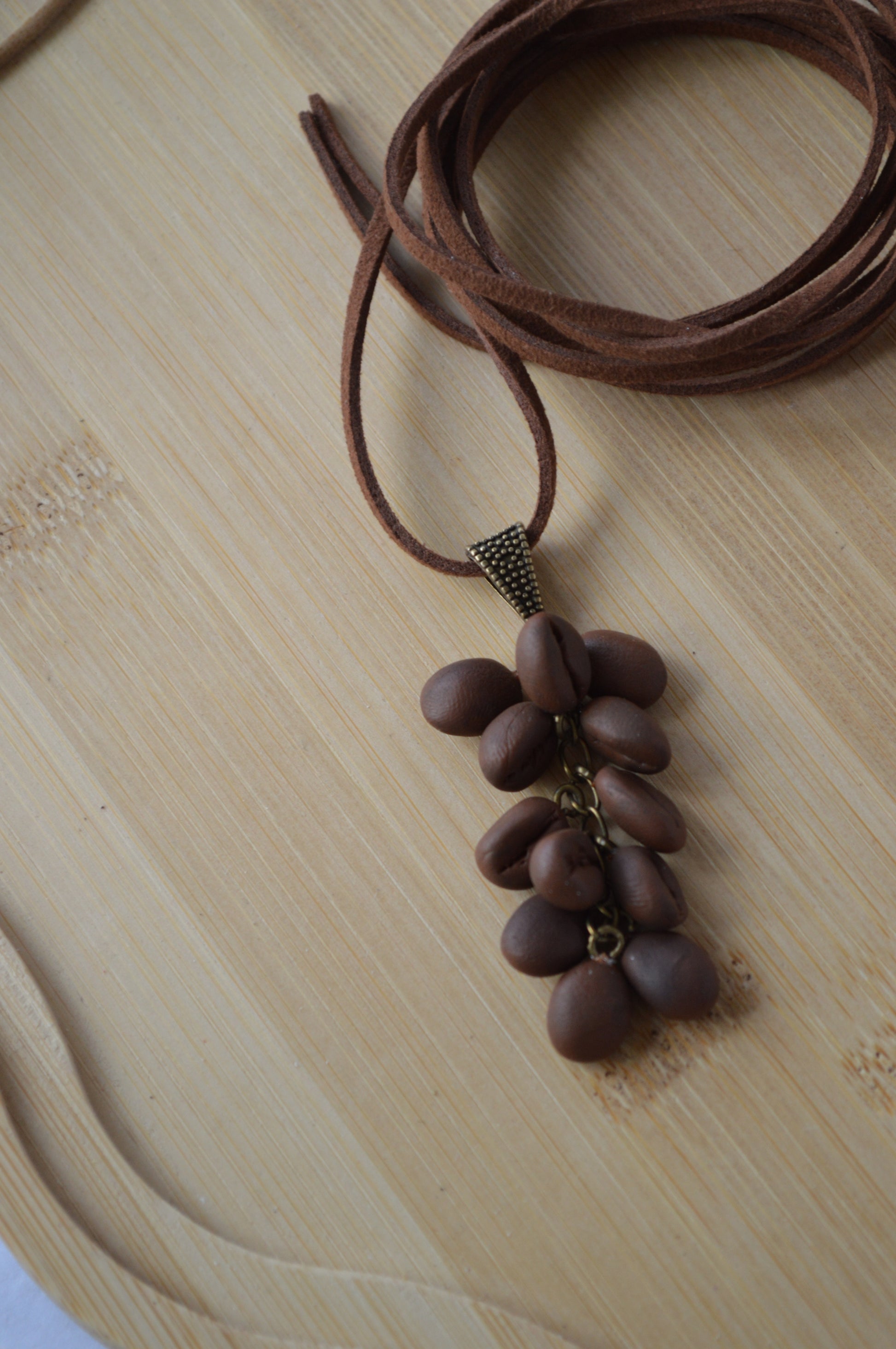 Brown necklace with bean-shaped beads on a light wooden surface