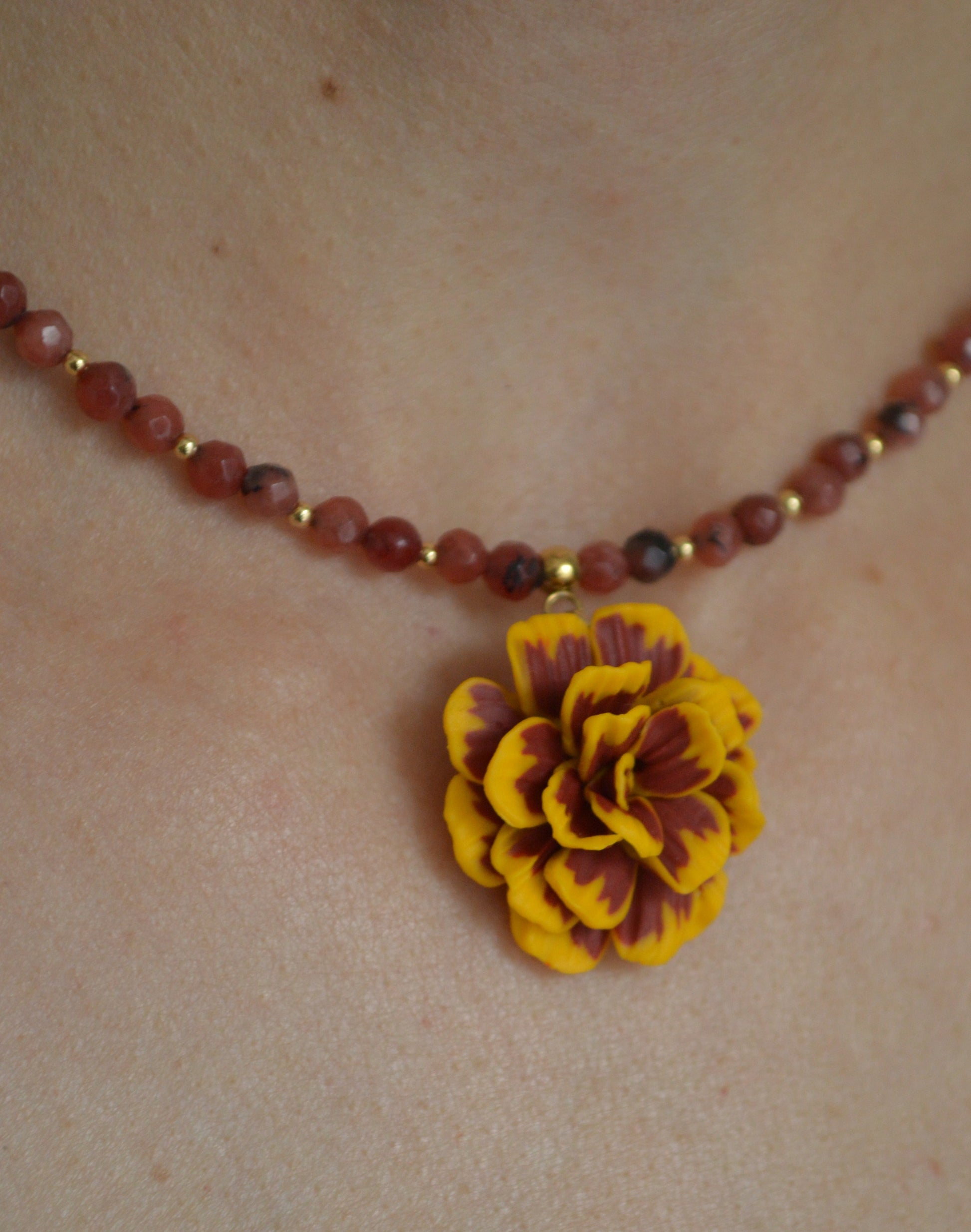 Necklace with a yellow flower pendant on a skin background