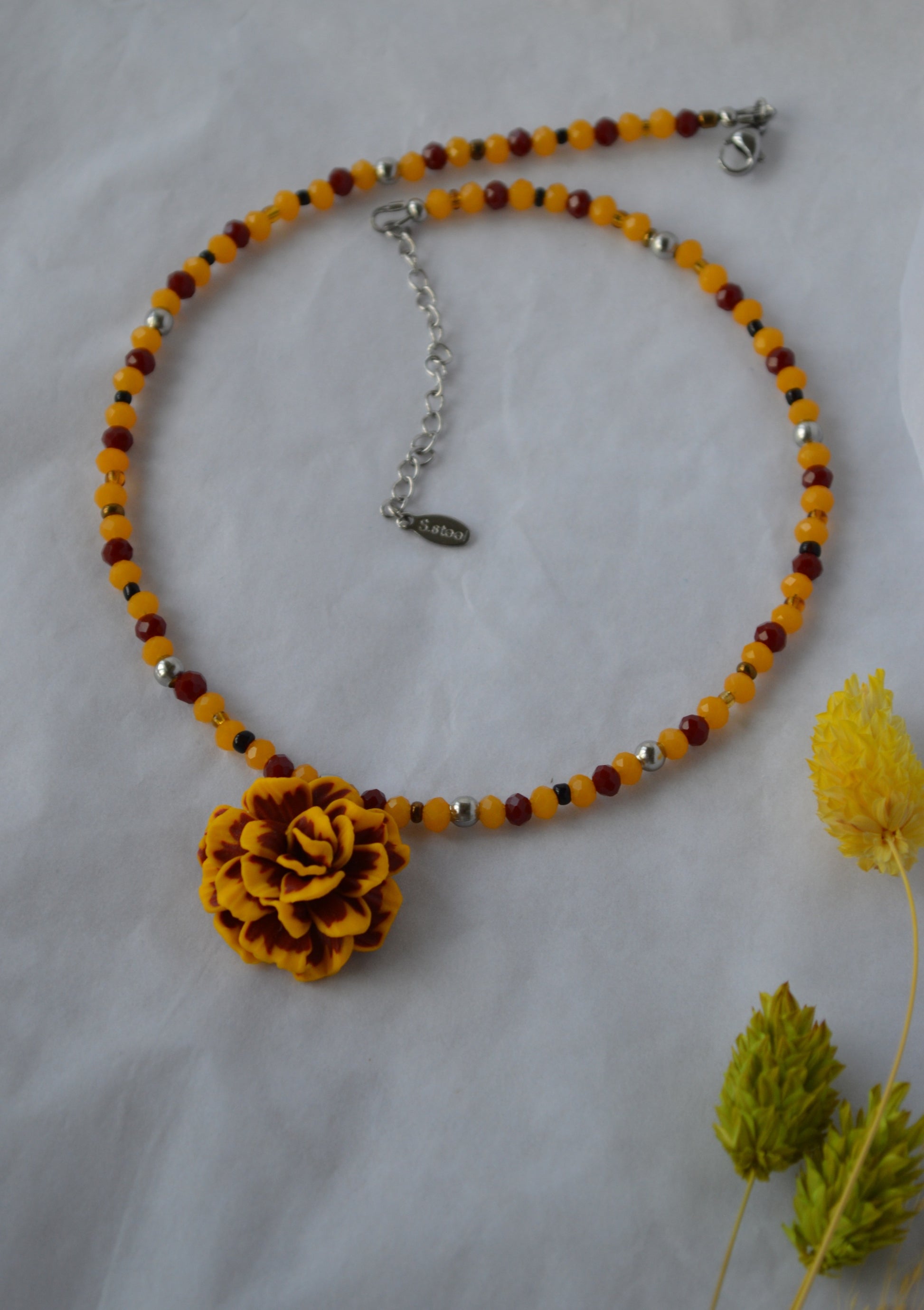 Necklace with a yellow marigold flower pendant and a beaded chain