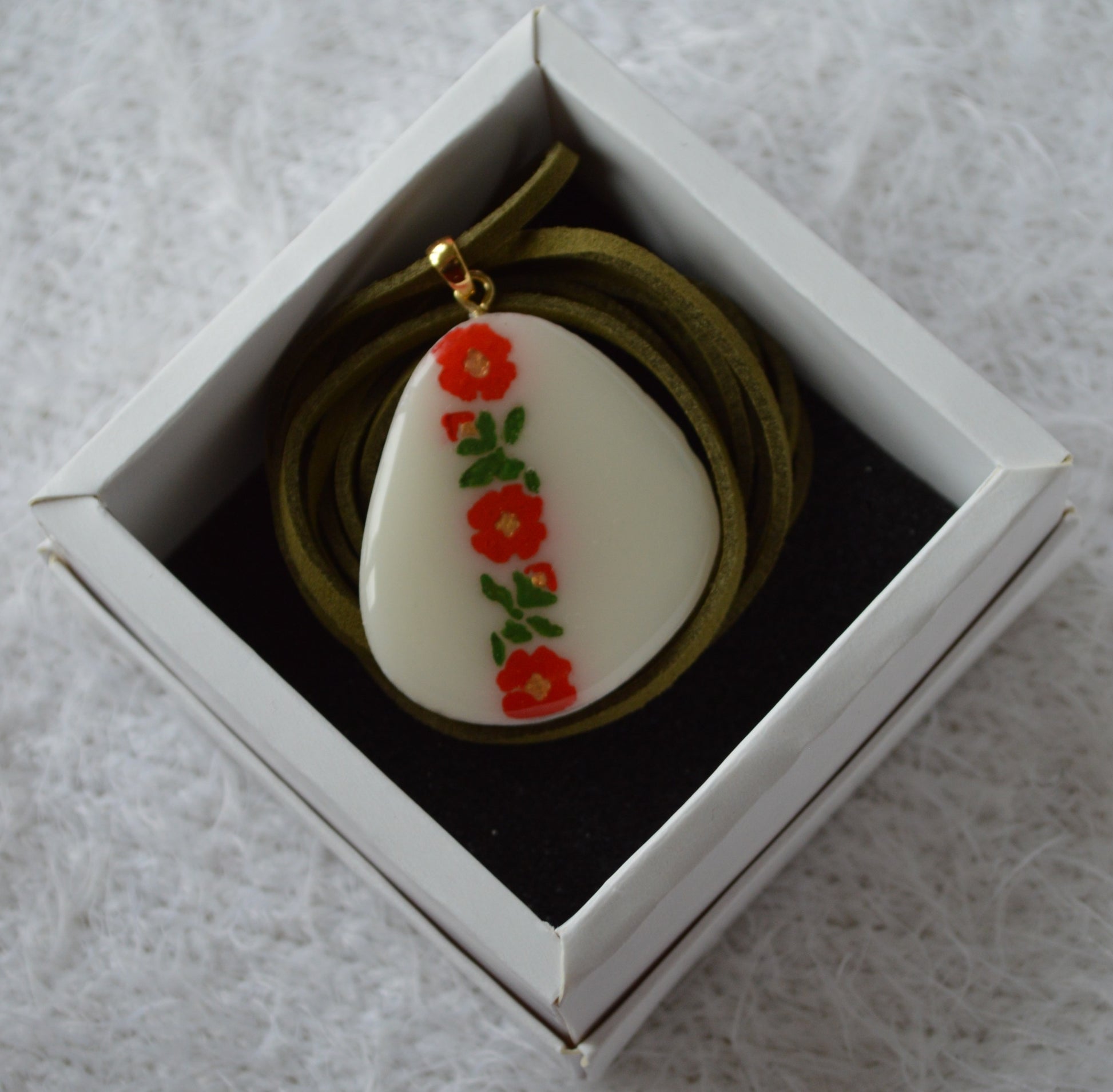 pidviska na shnurochku bila з червоно зеленим візерунком